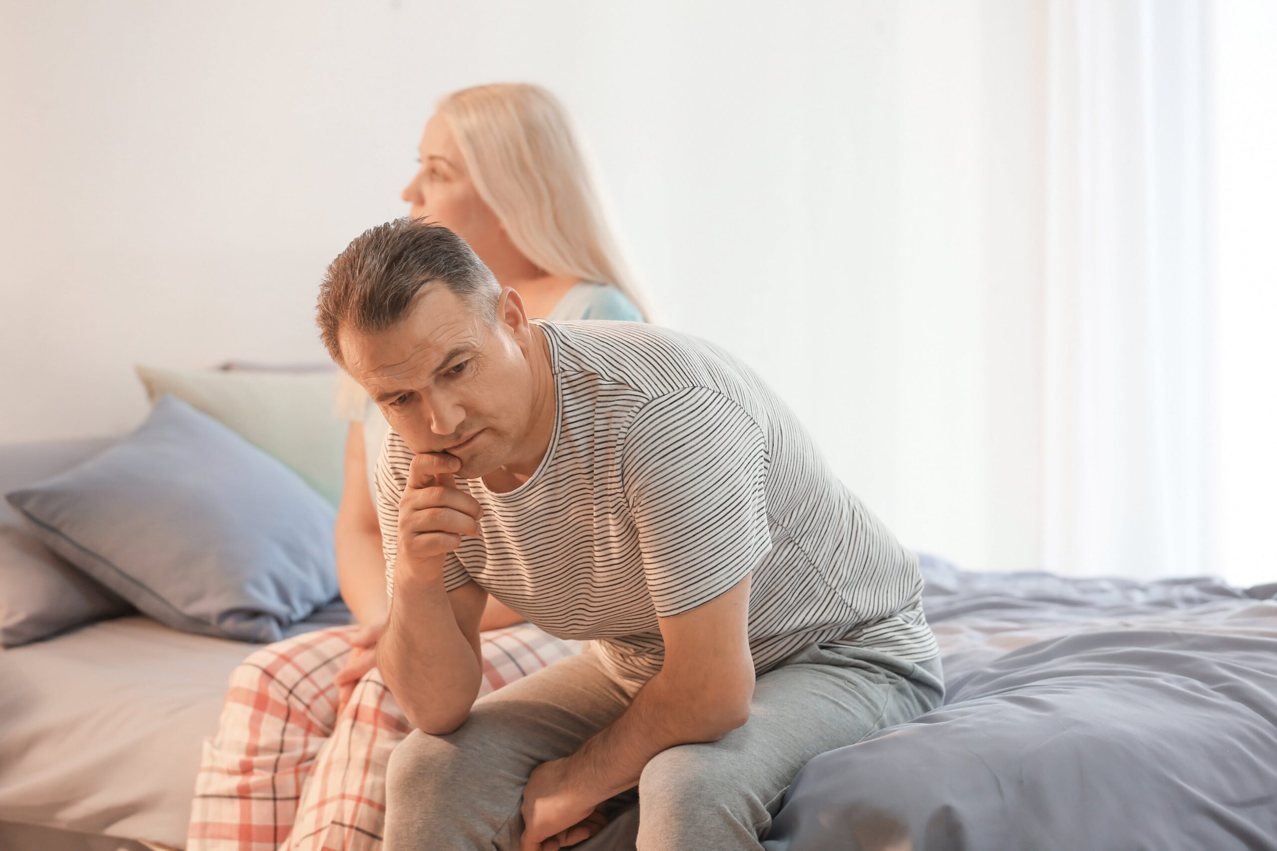 couple sitting on bed not talking