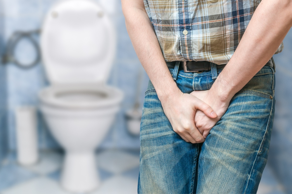 Man wants to pee and is holding his bladder.
