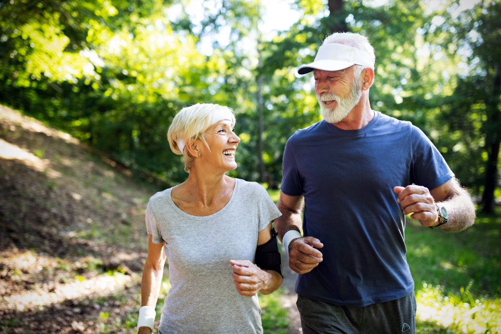 Older man and woman on a run outside