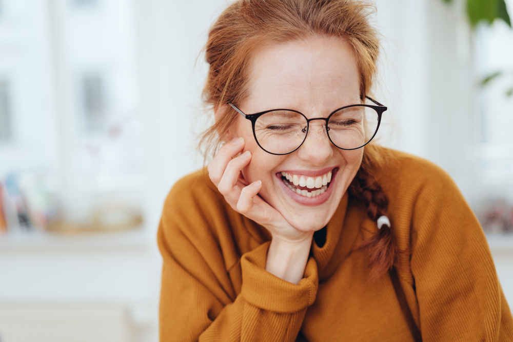 woman laughing with her eyes closed.