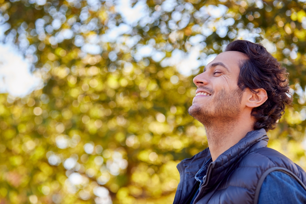 happy man in 30s outside smiling